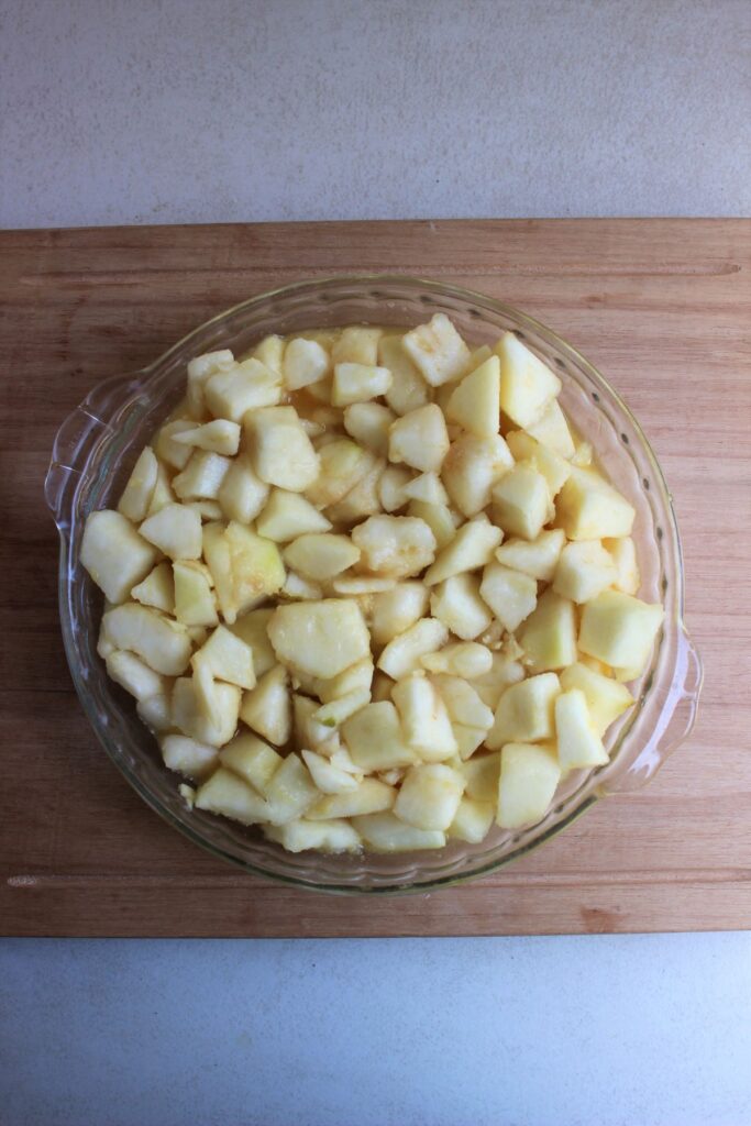 Round baking dish with pears on a wooden board.